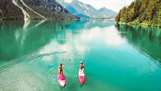 Zwei Stand-Up-Paddler auf dem Heiterwangersee in der Nähe des Familienhotels Kaiserhof in Berwang in der Tiroler Zugspitzarena