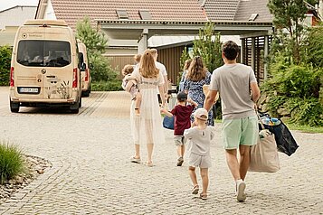 Die Familie ist eben angereist und geht mit Ihrem Gepäck in Richtung Rezeption des Familienhotels Seeklause an der Ostsee.