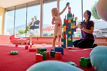 Kinder bauen aus Bauklötzen einen Turm im Happy-Club im Familienhotel Amiamo im Salzburger Land.