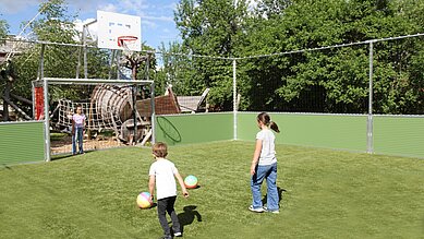 Kinder spielen auf dem Fußballfeld des Familienhotels Kinderhotel Stefan in Tirol Fußball.