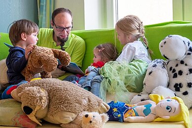 Betreuer liest Kinder ein Buch vor im Happy-Club im Familienhotel Mein Krug im Fichtelgebirge.