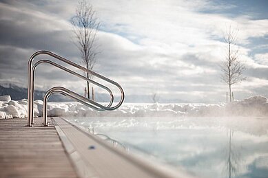 Blick auf den beheizten Aussen-Pool im Winter im Family Home Alpenhof in Südtirol