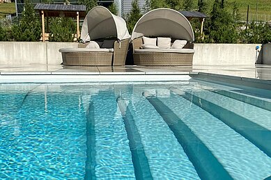 Blick auf den Infinity-Pool mit Liegeinseln im Familienhotel Bella Vista in Südtirol