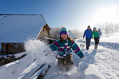 Spielendes Kind im Schnee im Schwarzwald-Familienurlaub.