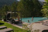 Familie genießt die Sonne und planscht im Außenpool des Familienhotels Engel Gourmet & Spa