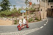 Geschwister fahren gemeinsam auf dem Dreirad im Familienhotel Seeklause an der Ostsee.