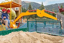 Vater und Tochter spielen auf dem Outdoor-Spielplatz vom Kaiserhof mit dem Bagger