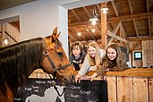 Drei Teenager im neuen Begegnungsstall mit Pferden im Landhaus zur Ohe im Bayerischen Wald.