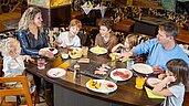 Familie speist im Restaurant mit Tischgrill im Familienhotel Feldberger Hof.