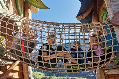 Kinder spielen auf dem Outdoor-Spielplatz des Kinderhotels Stefan.