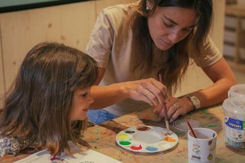 Mutter malt gemeinsam mit ihrer Tochter ein buntes Bild im Familienhotel Engel Gourmet & Spa