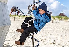 Kinder spielen auf den Außenspielplätzen der Deichkrone.