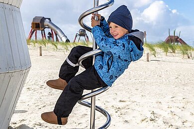 Kinder spielen auf den Außenspielplätzen der Deichkrone.