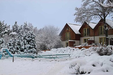 Die Winteransicht auf den außenbereich des Familienhotels Family Club Harz.