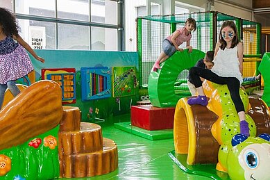 Kinder toben auf Spielsteinen im Indoorspielplatz Rhönräuberpark