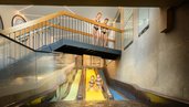 Kinder rutschen nebeneinander auf drei farbigen Wasserrutschen im Familienhotel Alpenhotel Kindl in ein Erlebnisbecken.