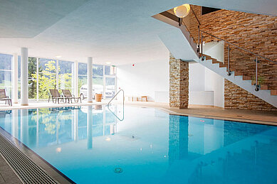 Indoor-Schwimmbad mit Liegen im Familienhotel Alphotel im Allgäu.