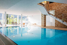 Indoor-Schwimmbad mit Liegen im Familienhotel Alphotel im Allgäu.