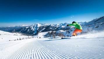 Ein Skifahrer auf der Skipiste im Skigebiet Zauchensee mit herrlichem Blick in die Berge.