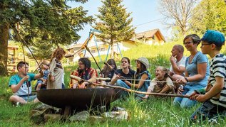 Stockbrot in einer Lagerfeuerrunde mit Kindern und Eltern im Familienhotel Mein Krug im Fichtelgebirge.