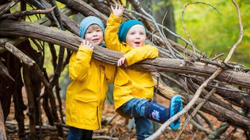 Zwei Jungs spielen mit Stöcken und Holz in der Natur