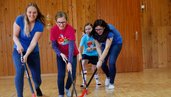 Kinder und Betreuerinnen beim Landhockeyspielen in der Turnhalle des Familienhotels Ramsi