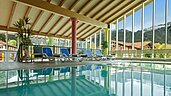 Schwimmbad mit Liegen und Panoramafenstern im Familienhotel Spa- & Familien-Resort Krone im Allgäu.