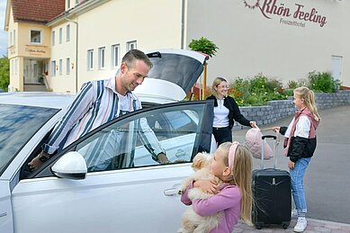 Familie steigt aus dem Auto aus und kommt im Familienurlaub im Familienhotel Rhön Feeling an.