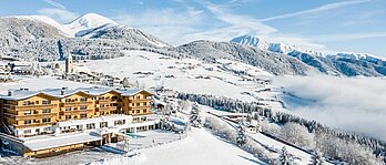 Luftaufnahme des Familienhotels Family Home Alpenhof im Winter.