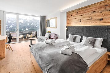 Große, helle Suite mit Couch und großem Doppelbett im Familienhotel Allgäuer Berghof.