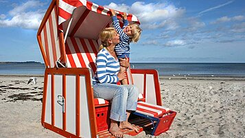 Mutter und Kind genießen die Sonne im Strandkorb an der Nordsee