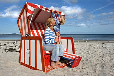 Mutter und Kind genießen die Sonne im Strandkorb an der Nordsee