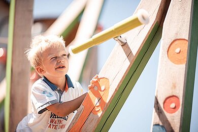 Ein Kind auf dem Kinderspielplatz im Family Home Alpenhof in Südtirol.