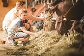 Zwei Jungs füttern die Küche auf dem Bauernhof des Familienhotels Landgut Furtherwirt in Tirol.