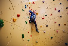 Junge klettert an der Boulderwand im Familienhotel Kirchheimerhof in Kärnten.