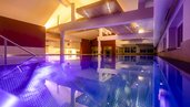 Heaven-Pool mit schöner, lilafarbener Ambienten-Beleuchtung im Familienhotel Galtenberg Family & Wellness Resort in Tirol.