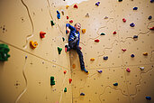 Junge klettert an der Boulderwand im Familienhotel Kirchheimerhof in Kärnten.