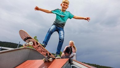 Ein Junge auf einem Skateboard im Skatepark im Familienhotel Elldus Resort im Erzgebirge