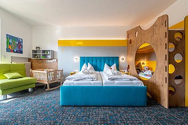 Familienzimmer mit Kinderbett und Babywiege im Familienhotel Mein Krug im Fichtelgebirge.