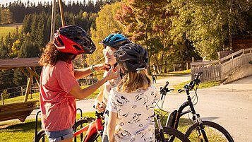 Eine Mama fährt mit Ihren Kinder Fahrrad.