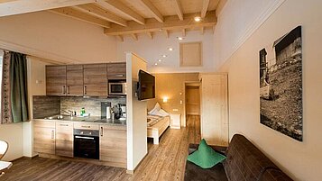 Geräumige Familiensuite mit Küchenzeile und Wohnbereich im Spa- & Familien-Resort Krone im Allgäu.