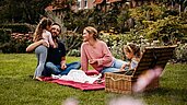 Familie beim Picknick in der Natur auf dem Außengelände des Familienhotels Landhaus Averbeck in der Lüneburger Heide.