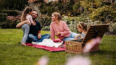 Familie beim Picknick in der Natur auf dem Außengelände des Familienhotels Landhaus Averbeck in der Lüneburger Heide.