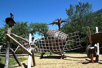 Ein Junge spielt auf dem Kletterspielplatz vom Kinderhotel Stefan in Pitztal.