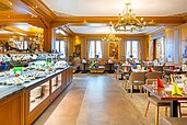 Elegantes Restaurant im Hotel Feldberger Hof mit einem reichhaltigen Buffet und dekorierten Tischen unter prachtvollen Kronleuchtern.