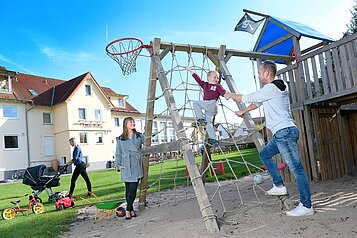 Familie mit spielt gemeinsam auf dem Außenspielplatz des Familienhotels Rhön Feeling.