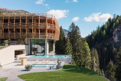 Neubau des Familienhotel Bella Vista in Südtirol mit Infinity Pool, Sonnenterrasse und Blick auf die Berge.