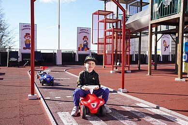 Junge sitzt auf dem Bobbycar auf dem Außenbereich des Familienhotels Feldberger Hof.