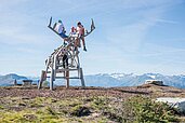 Familie mit zwei Kleinkindern beim Wandern durch die sommerliche Natur in Südtirol.