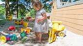 Kind spielt mit vielen Sandförmchen im Sandkasten im Familienhotel Ulrichshof im Bayerischen Wald